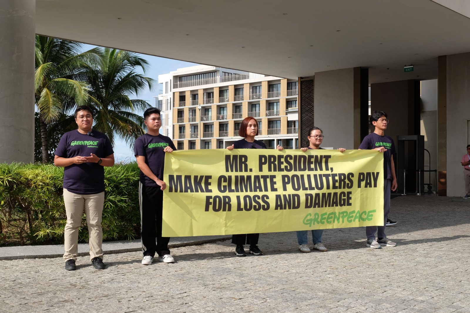 Activists display a banner calling on President Marcos Jr to demand payments from fossil fuel giants. [photo credit: Greenpeace/Victor Kintanar]